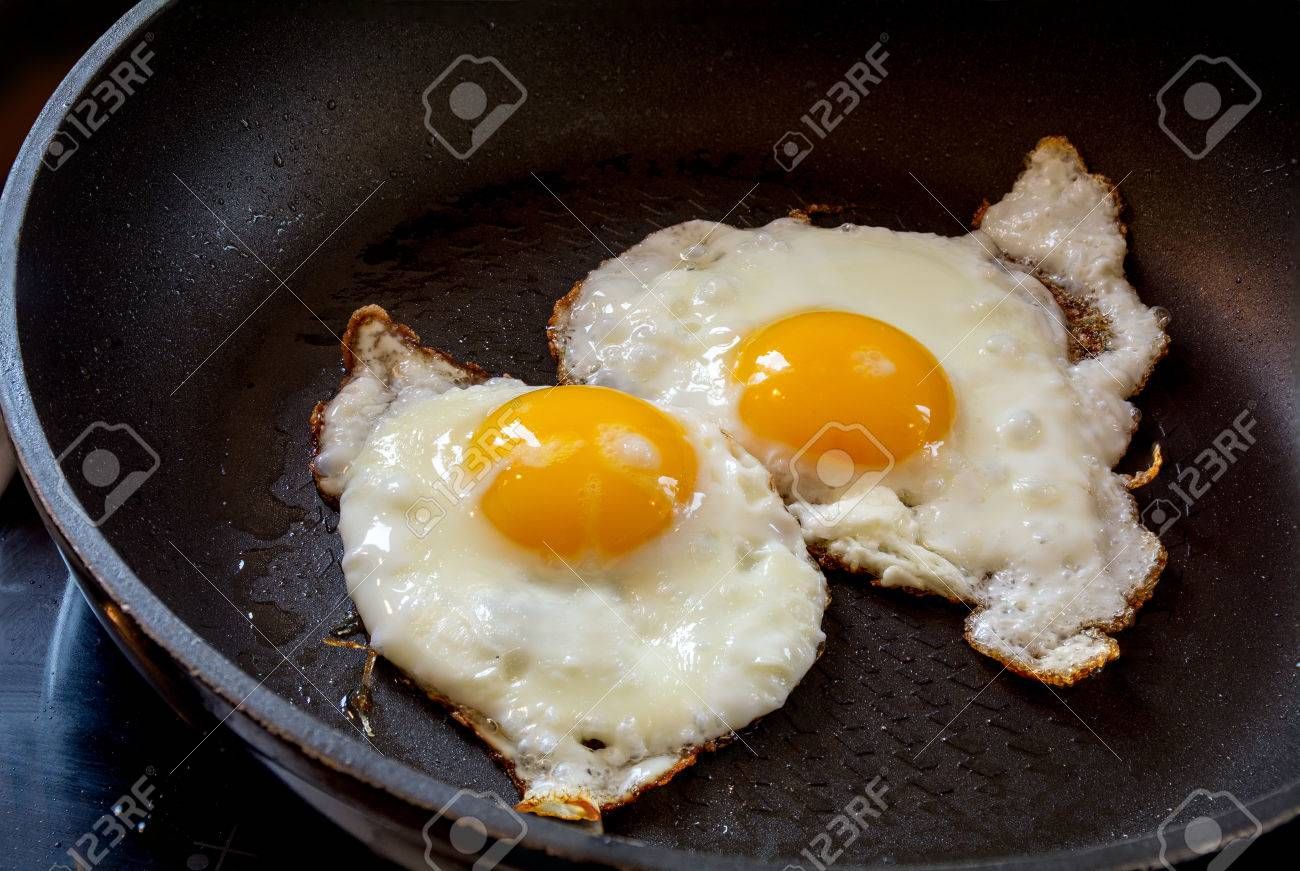 37218707-two-fried-eggs-in-a-black-pan-breakfast-preparation.jpg